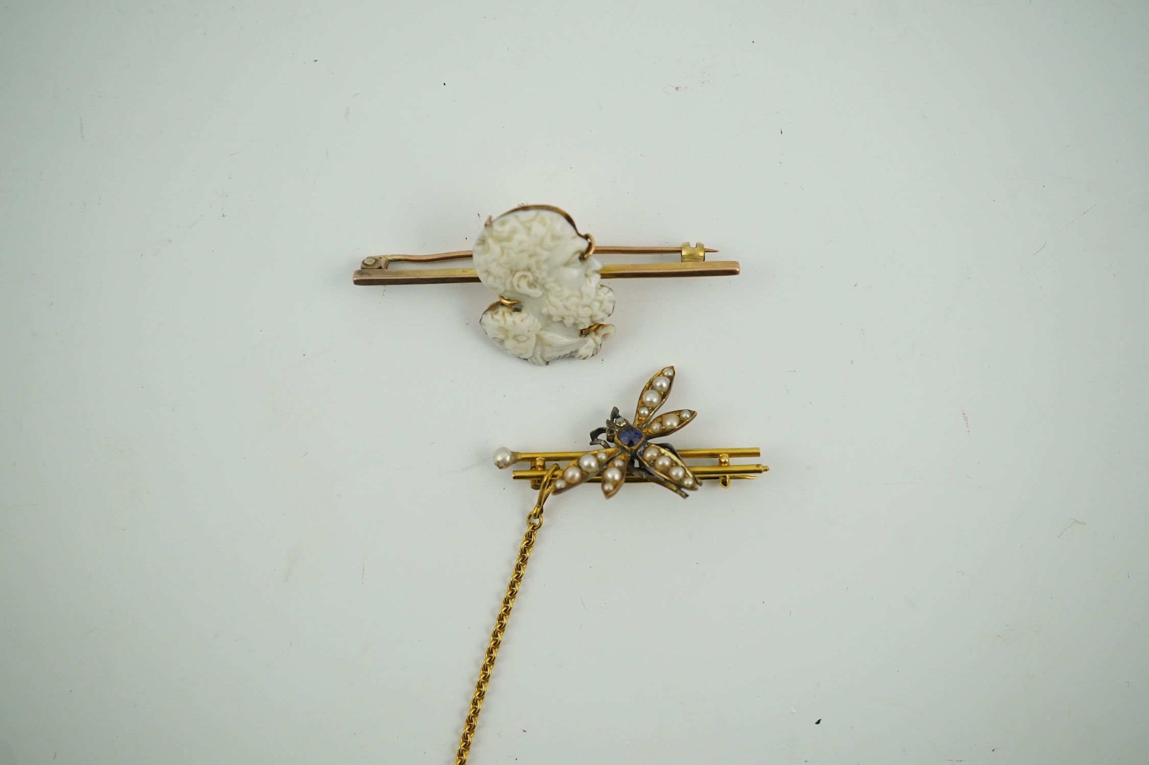 An Edwardian 15ct mounted cameo shell bar brooch, 49mm, together with a yellow metal, sapphire and split pearl cluster set dragonfly bar brooch, 11 grams. Condition - fair